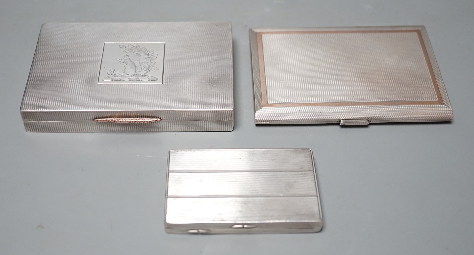 A George VI engine turned silver rectangular cigarette box/case, engraved with a squirrel, W.H. Manton Ltd, Birmingham, 1942, 12.2cm, one other Mappin & Webb silver cigarette case and a continental white metal snuff box.